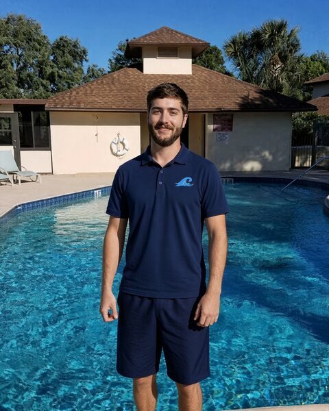 Christopher Amicucci, owner of Honest Pool Service LLC, standing poolside in a Honest Pool Service shirt